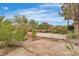 Backyard featuring stone paving, mature trees and shrubs with a view of fence and greenery beyond at 5889 Taylor Valley Ave, Las Vegas, NV 89131