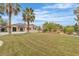 Lush backyard showcasing a green lawn, mature trees, and a glimpse of the inviting pool, perfect for outdoor living at 5889 Taylor Valley Ave, Las Vegas, NV 89131