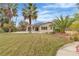 Beautiful backyard with a sprawling lawn, mature landscaping, and a glimpse of the inviting swimming pool at 5889 Taylor Valley Ave, Las Vegas, NV 89131