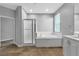Bright bathroom featuring a soaking tub, tiled floor, and separate glass-enclosed shower at 5889 Taylor Valley Ave, Las Vegas, NV 89131