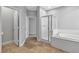 Bathroom view showcasing a soaking tub, glass-enclosed shower, and tiled flooring at 5889 Taylor Valley Ave, Las Vegas, NV 89131