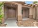 Inviting covered entryway with double doors, stone accents, desert landscaping, and a tranquil ambiance at 5889 Taylor Valley Ave, Las Vegas, NV 89131