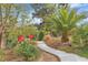 A sidewalk winds through beautiful landscaping with trees, bushes and red roses at 5889 Taylor Valley Ave, Las Vegas, NV 89131
