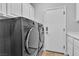 Modern side by side gray washer and dryer and access door can be seen in laundry room at 5889 Taylor Valley Ave, Las Vegas, NV 89131