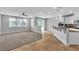 Open-concept room with tile flooring leading to carpeted living area and modern kitchen at 5889 Taylor Valley Ave, Las Vegas, NV 89131
