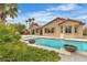 The backyard features a refreshing pool and desert landscaping with palm trees at 5889 Taylor Valley Ave, Las Vegas, NV 89131