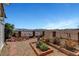 Landscaped backyard with gravel, brickwork, and mature plants, with mountain views beyond the decorative fence at 621 Mount Elbert Way, Boulder City, NV 89005