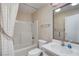 This bathroom has wallpapered walls, a shower-tub combo, and a white vanity with a large mirror at 621 Mount Elbert Way, Boulder City, NV 89005