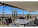 The home's covered patio has mountain views, comfortable seating, and desert foliage at 621 Mount Elbert Way, Boulder City, NV 89005
