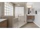Bathroom featuring dual sinks, a glass shower, and bright lighting fixtures at 6308 Canyon Ridge Dr, Las Vegas, NV 89108