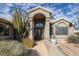 Beautiful home entry featuring an arched doorway, mature landscaping, and decorative features at 6308 Canyon Ridge Dr, Las Vegas, NV 89108