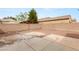 View of the backyard featuring a gravel yard, patio area, and mature landscaping at 6512 N Bruce St, North Las Vegas, NV 89086