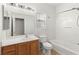 Bathroom with wood vanity, mirror, shower and tub combination and toilet at 6512 N Bruce St, North Las Vegas, NV 89086