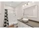 A stylish bathroom featuring a modern vessel sink, shower with geometric curtain, and updated lighting at 6512 N Bruce St, North Las Vegas, NV 89086