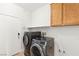 A laundry room featuring new washer and dryer, upper cabinets and neutral walls at 6512 N Bruce St, North Las Vegas, NV 89086