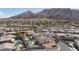 Expansive aerial view showcasing a residential area with tile roof homes, pools, and mountain views at 6638 Dazzling Heights Ln, Las Vegas, NV 89110