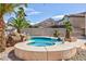 Inviting pool and spa area with rock features and lush tropical landscaping at 6638 Dazzling Heights Ln, Las Vegas, NV 89110