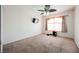 Bright bedroom featuring a ceiling fan, large window, and carpet flooring, creating a comfortable retreat at 664 Mystic Cliffs Ave, Las Vegas, NV 89183