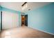 Bedroom with calming blue walls, modern light fixture, and a glimpse of a bathroom at 664 Mystic Cliffs Ave, Las Vegas, NV 89183