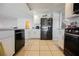 Bright kitchen featuring stainless steel appliances, white cabinetry, and tile flooring at 664 Mystic Cliffs Ave, Las Vegas, NV 89183
