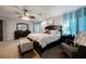 Well-lit main bedroom with carpet, ceiling fan, and decorative furniture at 664 Mystic Cliffs Ave, Las Vegas, NV 89183