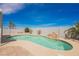 Backyard with a sparkling pool featuring a rock waterfall feature and desert landscaping at 664 Mystic Cliffs Ave, Las Vegas, NV 89183