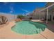 Sparkling in-ground pool with tanning ledge and rock waterfall surrounded by desert landscaping at 664 Mystic Cliffs Ave, Las Vegas, NV 89183
