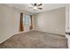 Large bedroom with ceiling fan, window, and neutral carpet at 6680 Caporetto Ln # 103, North Las Vegas, NV 89084