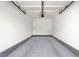 Spacious empty garage with painted walls, concrete floor, and overhead door opener, offering ample storage and parking at 6680 Caporetto Ln # 103, North Las Vegas, NV 89084