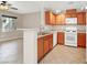 Open kitchen with wood cabinets, tile floor, and appliances at 6680 Caporetto Ln # 103, North Las Vegas, NV 89084