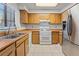 Traditional kitchen features wooden cabinets, white appliances, and a stainless steel refrigerator at 7084 Burcot Ave # D27, Las Vegas, NV 89156