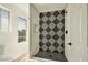 Modern bathroom featuring a stylish tiled shower with black hardware and a window at 744 Willow Ave, Henderson, NV 89002