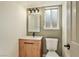 Cozy bathroom features a wood vanity, white countertop, and a framed mirror with decorative lighting at 744 Willow Ave, Henderson, NV 89002