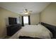 Relaxing bedroom featuring a plush bed, dark dresser and ceiling fan at 7653 Fabled Filigree St, Las Vegas, NV 89149