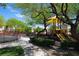 Community playground with slides and swings, surrounded by lush trees at 7653 Fabled Filigree St, Las Vegas, NV 89149