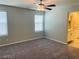 Bedroom featuring carpeted floors, neutral walls, a ceiling fan, and access to an ensuite bathroom at 7892 W Shelbourne Ave, Las Vegas, NV 89113
