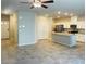 Open concept living room and kitchen with granite island, stainless steel appliances, and tile flooring at 7892 W Shelbourne Ave, Las Vegas, NV 89113