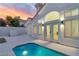Home exterior with pool and patio, illuminated by landscape lighting at dusk at 8125 Sunset Cove Dr, Las Vegas, NV 89128