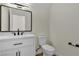 Well-lit bathroom featuring white cabinetry, a modern sink, and a toilet at 8125 Sunset Cove Dr, Las Vegas, NV 89128