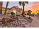 Charming home featuring a stone-accented garden and tiled roof, set against a beautiful sunset backdrop at 8125 Sunset Cove Dr, Las Vegas, NV 89128