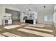 Open-concept living room featuring a kitchen with white cabinets and a large island with wood floors at 8125 Sunset Cove Dr, Las Vegas, NV 89128