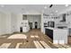 Open-concept kitchen with white cabinetry, a large island, and wood floors flowing into the living area at 8125 Sunset Cove Dr, Las Vegas, NV 89128