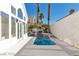 Private backyard oasis with a modern pool, clean white patio, and mature palm trees, perfect for relaxation at 8125 Sunset Cove Dr, Las Vegas, NV 89128
