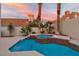 Serene backyard featuring a custom pool with attached spa, set amid lush palm trees and desert foliage at 8125 Sunset Cove Dr, Las Vegas, NV 89128