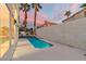 Beautiful backyard with a unique pool and spa combination, complemented by tall palm trees and a serene atmosphere at 8125 Sunset Cove Dr, Las Vegas, NV 89128