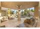 Luxurious covered patio with an outdoor kitchen, adjacent to a sparkling pool and landscaped yard at 8801 Rozetta Ct, Las Vegas, NV 89134