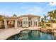 Gorgeous backyard pool area with lush landscaping, a rock waterfall spa, and a covered outdoor kitchen at 8801 Rozetta Ct, Las Vegas, NV 89134