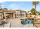 Lovely backyard pool with a built-in spa and covered patio featuring an outdoor kitchen and lounge area at 8801 Rozetta Ct, Las Vegas, NV 89134