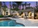 Charming pool with an outdoor fireplace, seating, and lush landscaping for a cozy and private backyard retreat at 8801 Rozetta Ct, Las Vegas, NV 89134