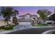 Beautiful two-story home with a three-car garage and well-manicured front yard with mature palm trees at 8801 Rozetta Ct, Las Vegas, NV 89134